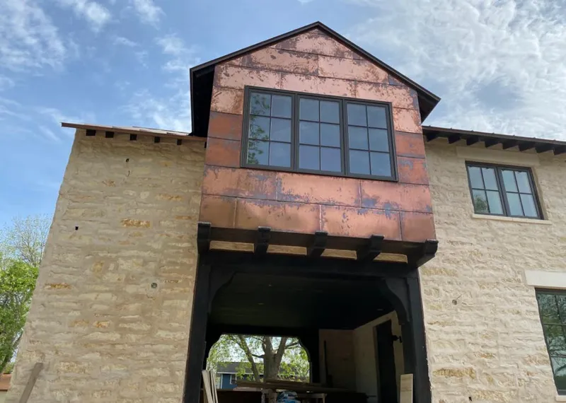Copper metal panel facade on a stone building for Roof Repair in Alpine